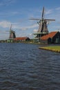 Colorful wooden windmills in the Zaanse Schans Museum stand on the river bank in Zaandam, the Netherlands.