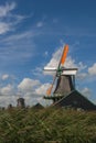 Colorful wooden windmills in the Zaanse Schans Museum in Zaandam, Netherlands, on a sunny day.