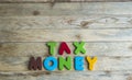 Colorful wooden word Tax and Money on wooden floor1