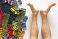 Colorful woolen socks and a pair of legs on white background Royalty Free Stock Photo