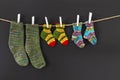 Colorful woolen socks on a rope on black background