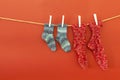 Colorful woolen socks on a rope on red background