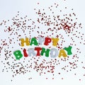 The colorful words HAPPY BIRTHDAY made from multicolored glitter letters on a white background with confetti Royalty Free Stock Photo