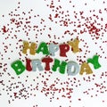 The colorful words HAPPY BIRTHDAY made from multicolored glitter letters on a white background with confetti Royalty Free Stock Photo