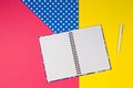 Open paper notebook and white pen on colorful background Royalty Free Stock Photo