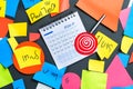 colorful sticky notes scattered around a calendar with a pen and a red target symbolizing goal setting and planning on a dark surf Royalty Free Stock Photo