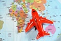 Colorful world map with airplane on it with the continents Africa, Europe, North America, Asia, South America, Australia and