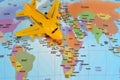 Colorful world map with airplane on it with the continents Africa, Europe, North America, Asia, South America, Australia and