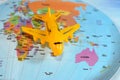 Colorful world map with airplane on it with the continents Africa, Europe, North America, Asia, South America, Australia and