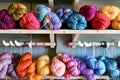 colorful yarn balls on shelf above a knitting station Royalty Free Stock Photo