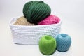 Multi-colored yarn lying in a white basket, crochet