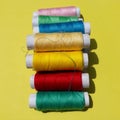 Colorful yarns on the yellow background.