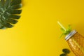 Colorful yellow background with mason jar glass cup, pineapple shape, summer juice or cocktail drink isolated. Summer holidays,