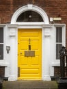 Colorful yellow door in old Dublin, Ireland. Entrance to Georgian style buildings in high value property area of the capital Royalty Free Stock Photo