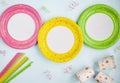 Colorful yellow, green, pink paper plates, Cup, straw.