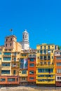 Colorful yellow and orange houses and famous house Casa Maso at the river Onyar, in Girona, vertical