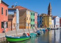 Colorfull facade Houses and bell tower on the island of Burano plus reflection in the water. Waterways with traditional boats Royalty Free Stock Photo