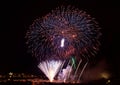 Colorfull fireworks explosion in the dark sky on the left side with the village silouthe on the bottom, popular fireworks show in