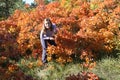 Colorfull smoke tree with sunset light caught in its leaves make autumn brighter lighter and a child plays in a bush