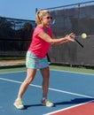 Colorfully dressed pickleball player with her eye on the ball