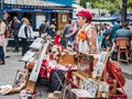 Colorfully dressed woman organ grinder sets up shop in Montmartre plaza, Paris