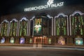 Colorfully illuminated stained glass windows and neon sign of historic FriedrichStadt Theater