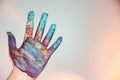 A colorfully painted hand on a white background