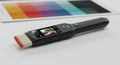 Colorimeter device displaying image with color palette chart on a white surface concept Royalty Free Stock Photo