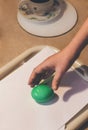 Coloring eggs for Easter. Hand picks up green egg from  tray Royalty Free Stock Photo