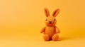 Colorized Knitted Orange Rabbit Toy On Yellow Background