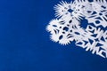 Background of various Christmas themed snowflakes cut out of white paper on a trendy blue background 2020 with a gift Royalty Free Stock Photo
