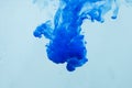 Colors dropped into liquid in motion. Ink swirling in water. Blue ink in water, abstract background Royalty Free Stock Photo