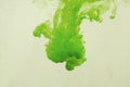 Colors dropped into liquid in motion. Ink swirling in water. Green ink in water, abstract background Royalty Free Stock Photo