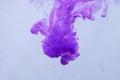 Colors dropped into liquid in motion. Ink swirling in water. Purple ink in water, abstract background Royalty Free Stock Photo