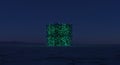 Neon green data cube structure in a dark desert Royalty Free Stock Photo