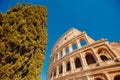 Colosseum or Coliseum ancient ruins background blue sky Rome, Italy, view from below, stone arches and sunrays Royalty Free Stock Photo