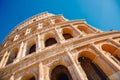 Colosseum or Coliseum ancient ruins background blue sky Rome, Italy, view from below, stone arches and sunrays Royalty Free Stock Photo