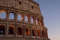 Colosseum, Rome, Italy. The outer wall of the evening coliseum. Arched openings are highlighted in orange backlighting.