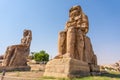 Colossi of Memnon statues under the sunlight and a blue sky in Luxor, Egypt Royalty Free Stock Photo