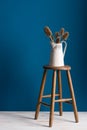 Colour Card and Vase on a Stool Over Blue Backdrop Royalty Free Stock Photo