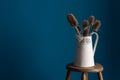 Colour Card and Vase on a Stool Over Blue Backdrop Royalty Free Stock Photo