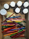 Colour pencils with medicine flask containers in storage box at workplace