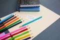 Colour pencils with notebooks and lying on pastel beige background. Back to school concept sign written. Colorful art studying and