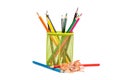 Colour pencils in pencil holder with color shavings on white