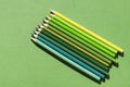 Colored pencils in green shades on a green background