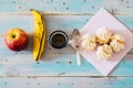 Coloured background with fresh food - closeup of some food in a blue table background - table of wood with an apple, banana, coffe