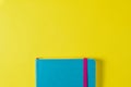 Coloured blue planner on a bright yellow background. The concept of finding ideas and inspiration for personal notes