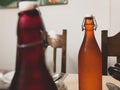 Coloured drink bottles with a rustic edge on a solid wooden dining table at a home indoors. Royalty Free Stock Photo