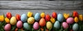 Coloured eggs and coloured tulips on grey wooden background. Easter style decoration banner. Holiday celebration greeting card.
