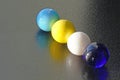 4 coloured marbles lined up - stock photo Royalty Free Stock Photo